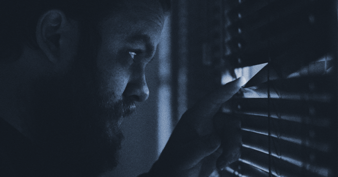 man som tittar ut genom fönster